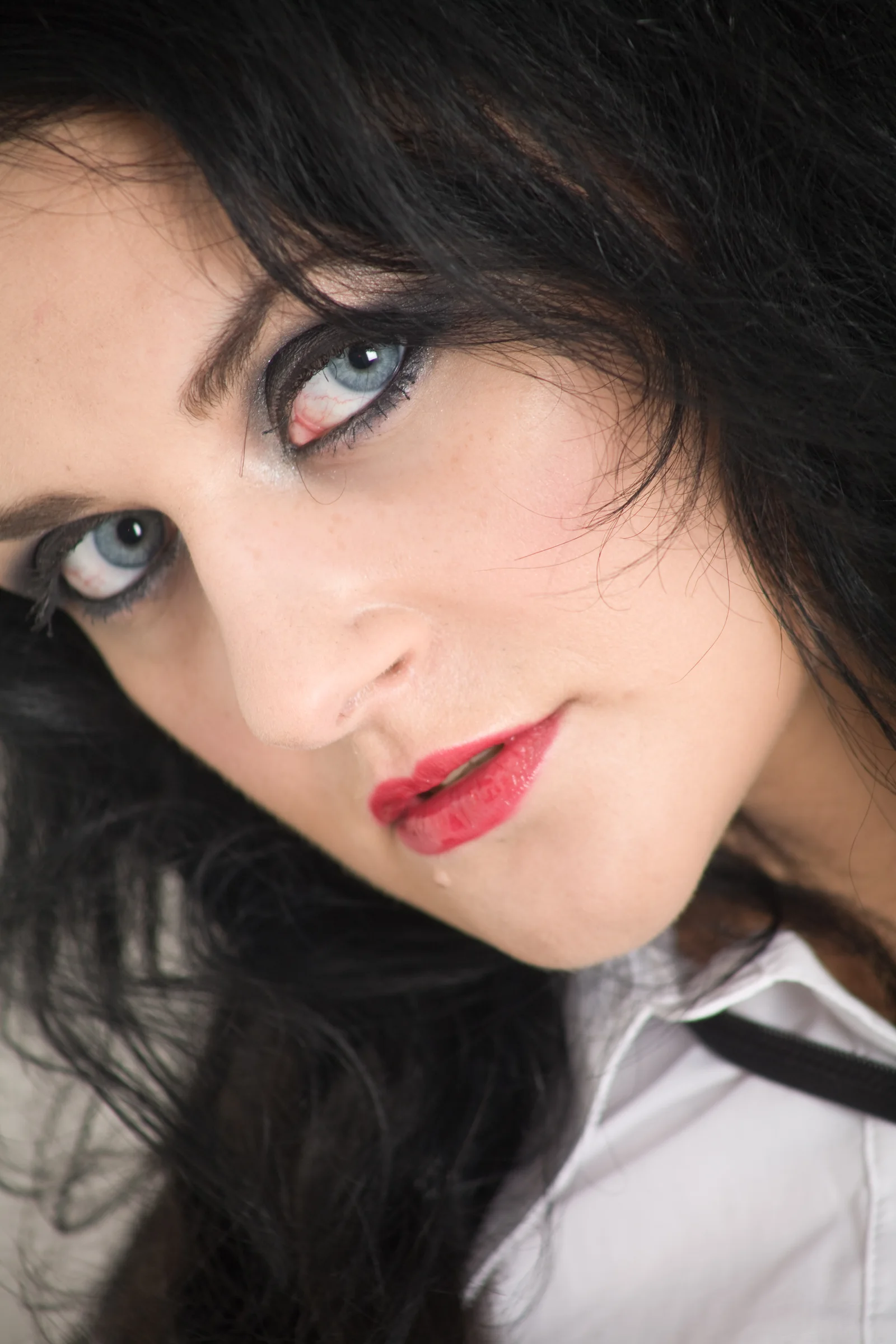 A close colour portrait and a monochrome portrait face one another across dark space.