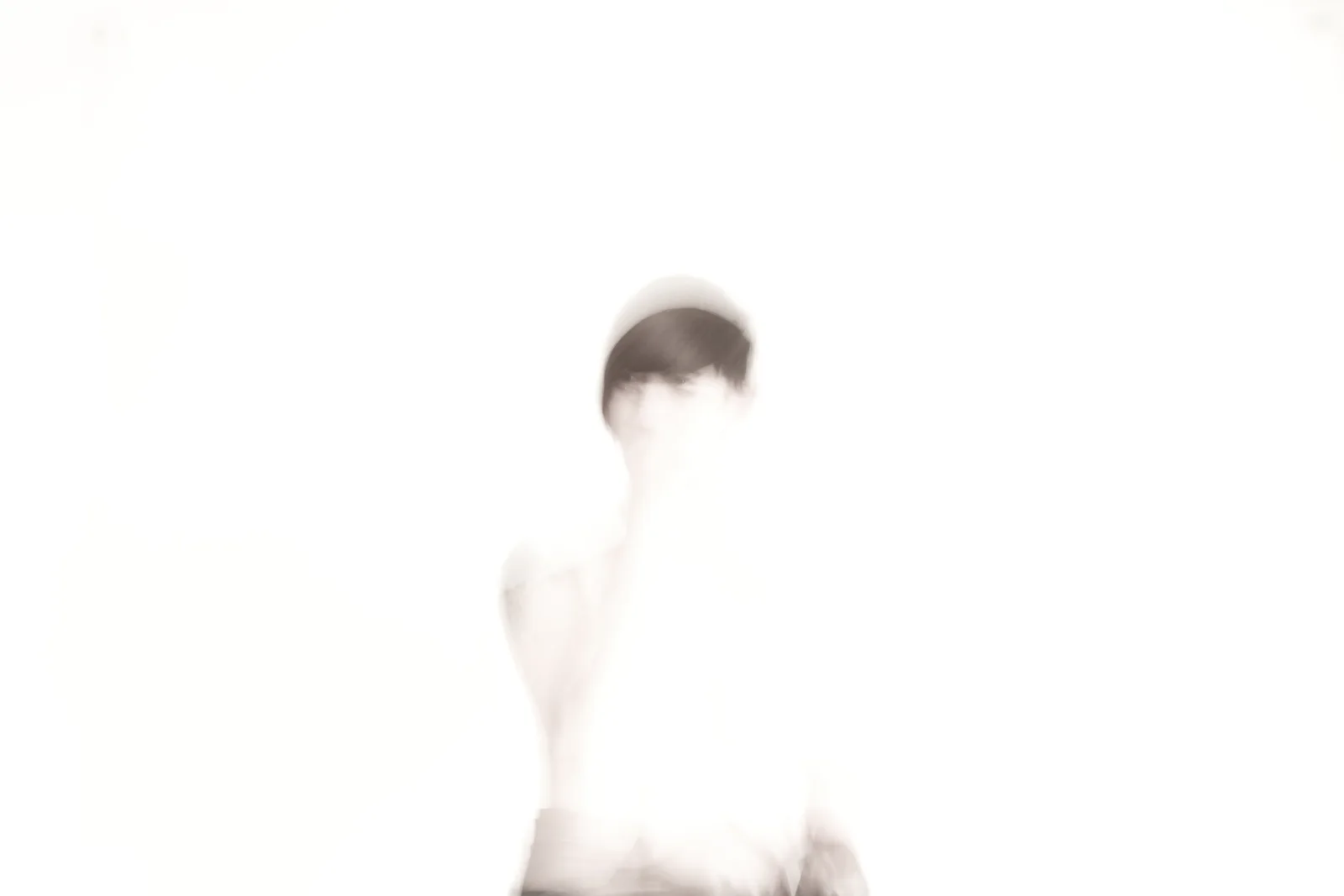 An overexposed human figure is barely retained by the white background.