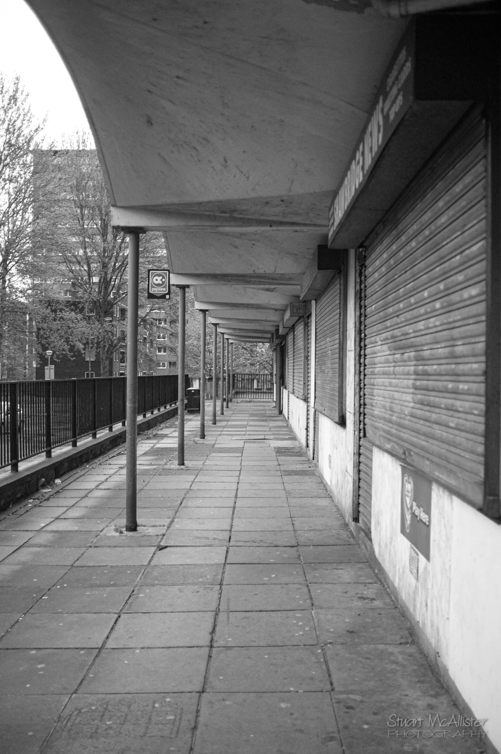 Closed openings and worn surfaces make the Shawbridge building feel sealed.
