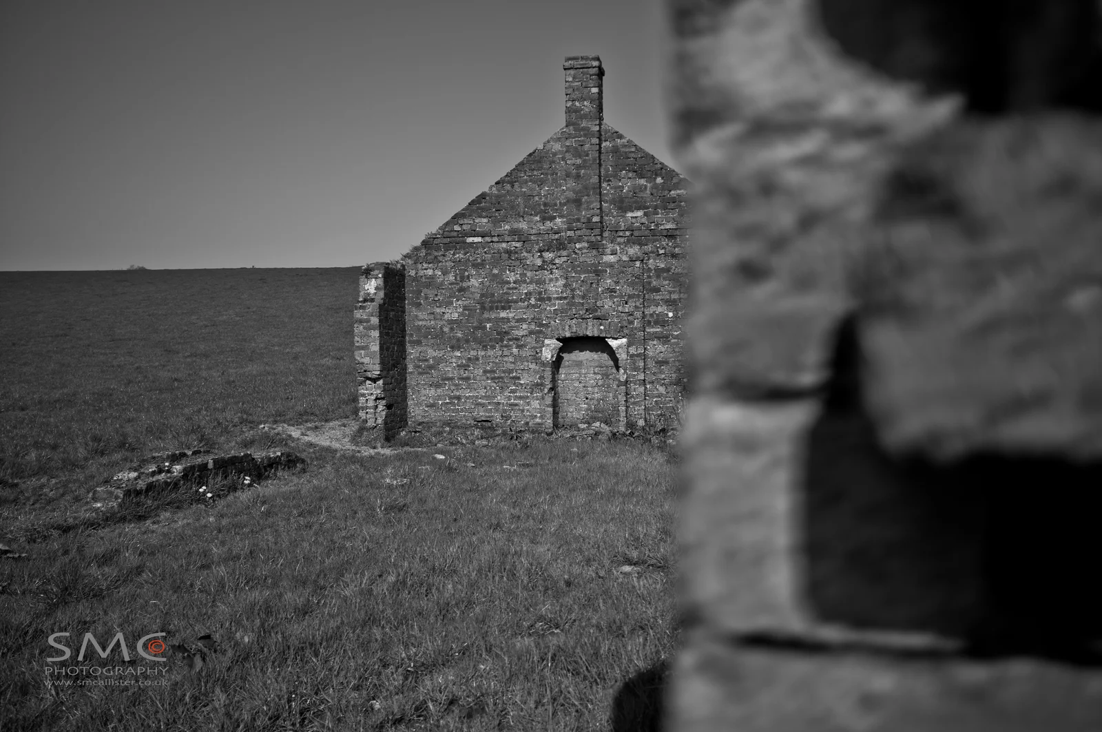 The bare outline of a vanished house stands within open space.