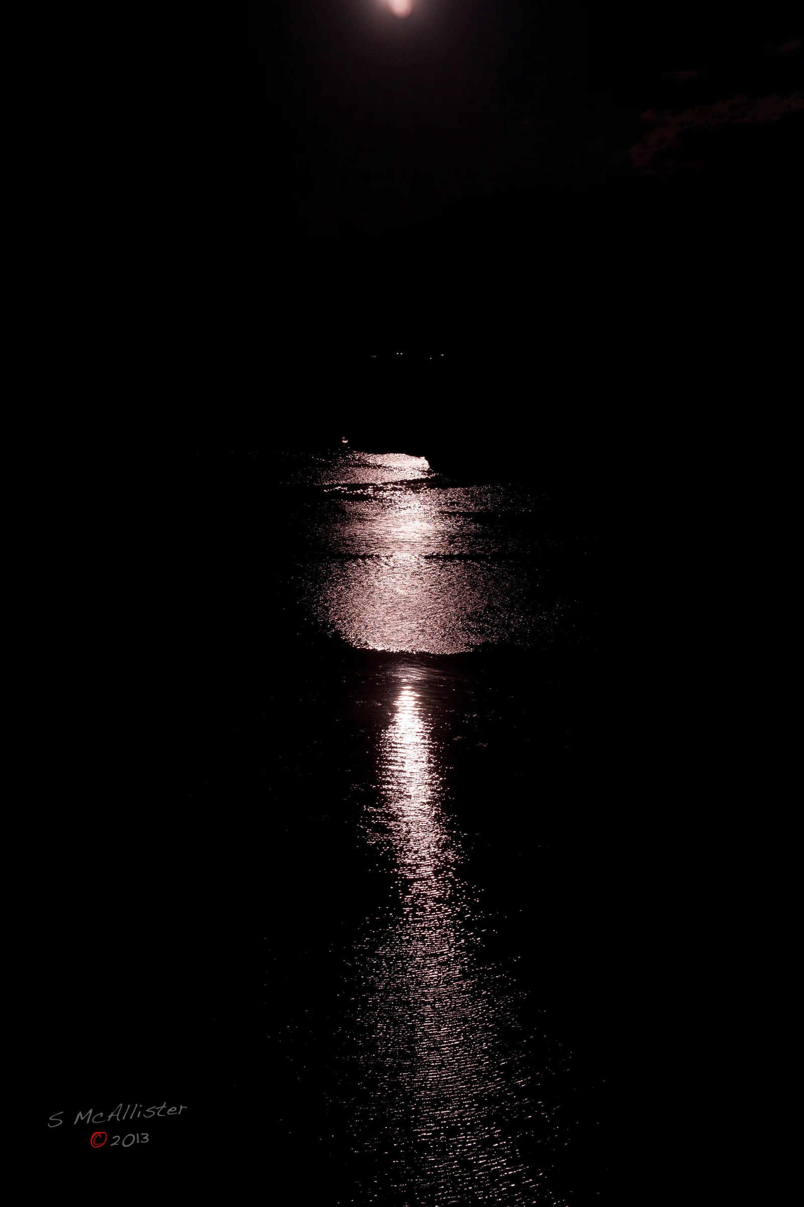 Moonlight forms a pale river through surrounding darkness.
